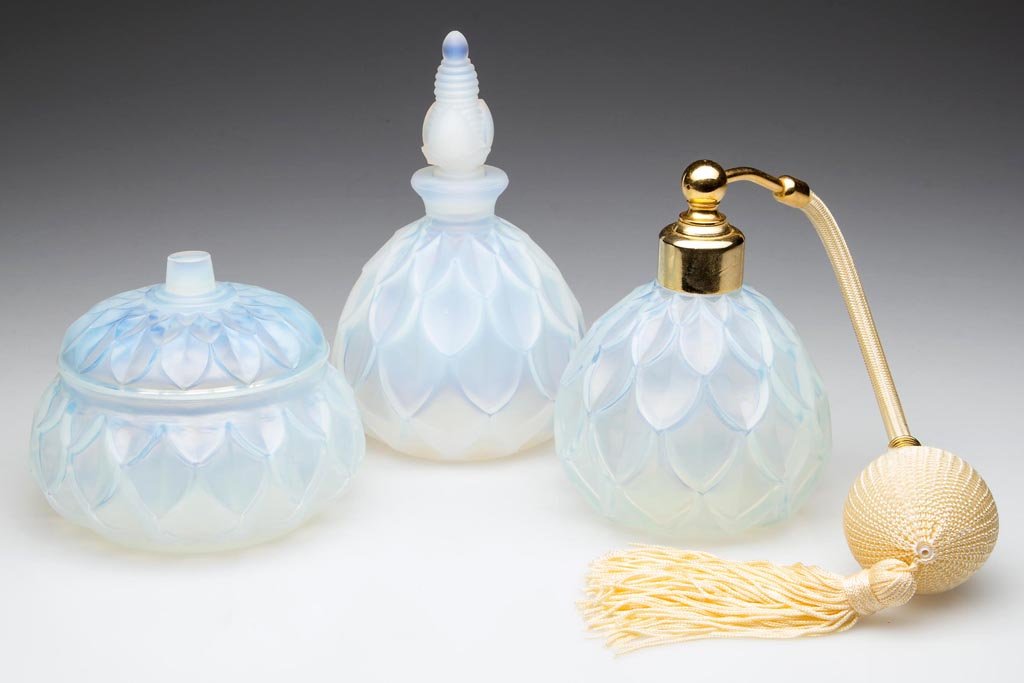 SABINO "PETALIA" THREE-PIECE DRESSER SET: SABINO "PETALIA" THREE-PIECE DRESSER SET, opalescent, comprising a powder box with cover, perfume bottle with original stopper, and an atomizer, each signed and/or embossed under base, atomizer with o