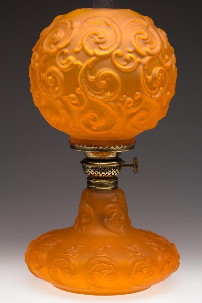 SMITH I, FIG. 288 / MOLDED SATIN GLASS JUNIOR PARLOR: SMITH I, FIG. 288 / MOLDED SATIN GLASS JUNIOR PARLOR MINIATURE LAMP, orange, matching patterned ball shade, embossed with overall fleur-de-lis pattern, period No. 1 collar. Fitted with a period Plume