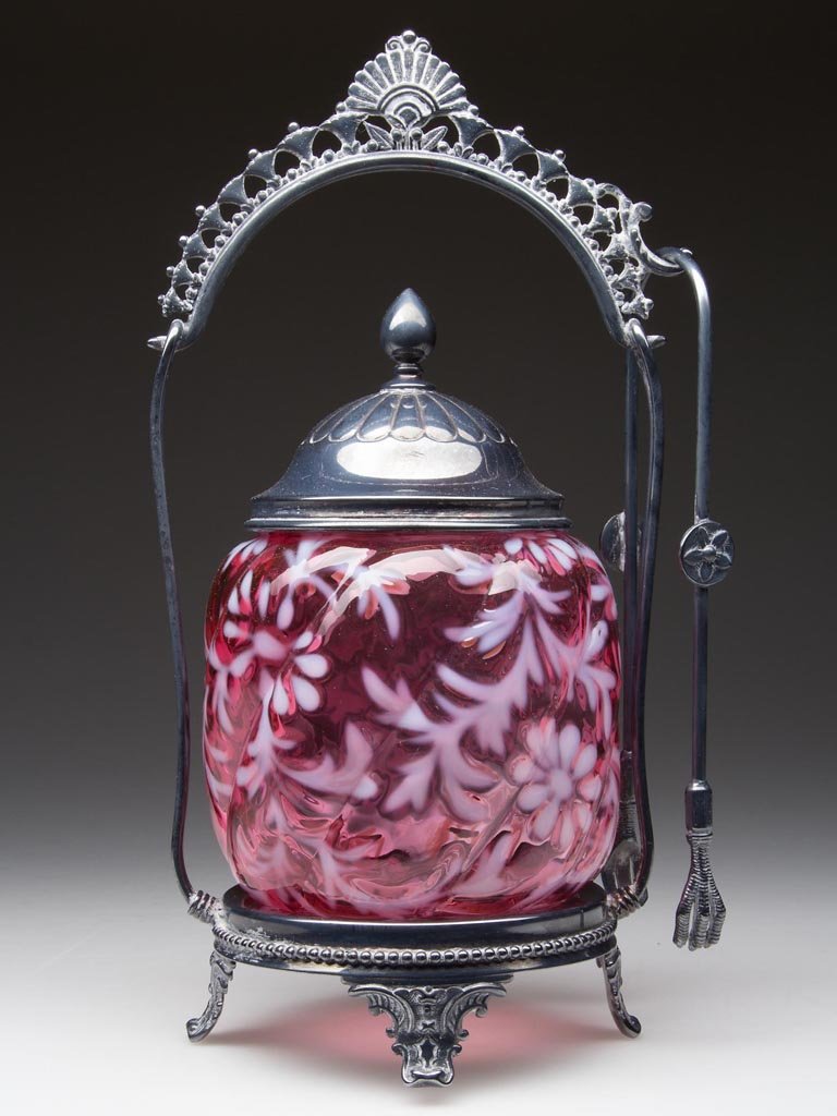 DAISY AND FERN - NORTHWOOD SWIRL PICKLE CASTER: DAISY AND FERN - NORTHWOOD SWIRL PICKLE CASTER, cranberry opalescent, fitted in a Meriden quadruple-plate frame, marked "291", with cover and tongs. Rim of jar polished during manufacturing process. N