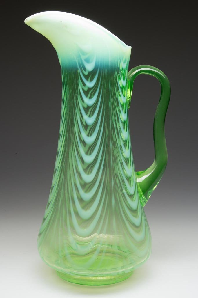 DRAPERY - BLOWN WATER PITCHER: DRAPERY - BLOWN WATER PITCHER, green opalescent, tankard form on low foot, with plain rim and applied handle. Northwood Glass Co. and others. Circa 1900-1910. 11 5/8" HOA. Provenance: From the collect