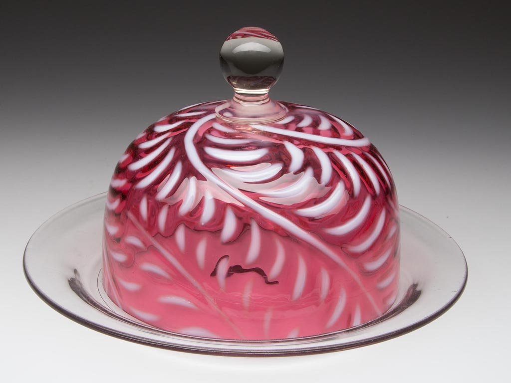 FERN COVERED BUTTER DISH: FERN COVERED BUTTER DISH, cranberry opalescent cover, colorless circular base with polished pontil mark, cover with colorless applied ball-form finial. West Virginia Glass Co. or Beaumont Glass Co. 18