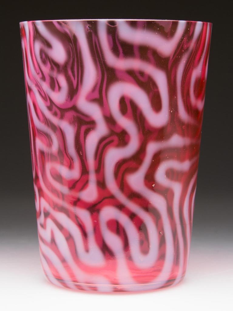 SWIRLING MAZE TUMBLER: SWIRLING MAZE TUMBLER, cranberry opalescent, factory polished rim. Attributed to the Jefferson Glass Co. Circa 1905. 4" H. Provenance: From the collection of Larry & Diana Nellans.