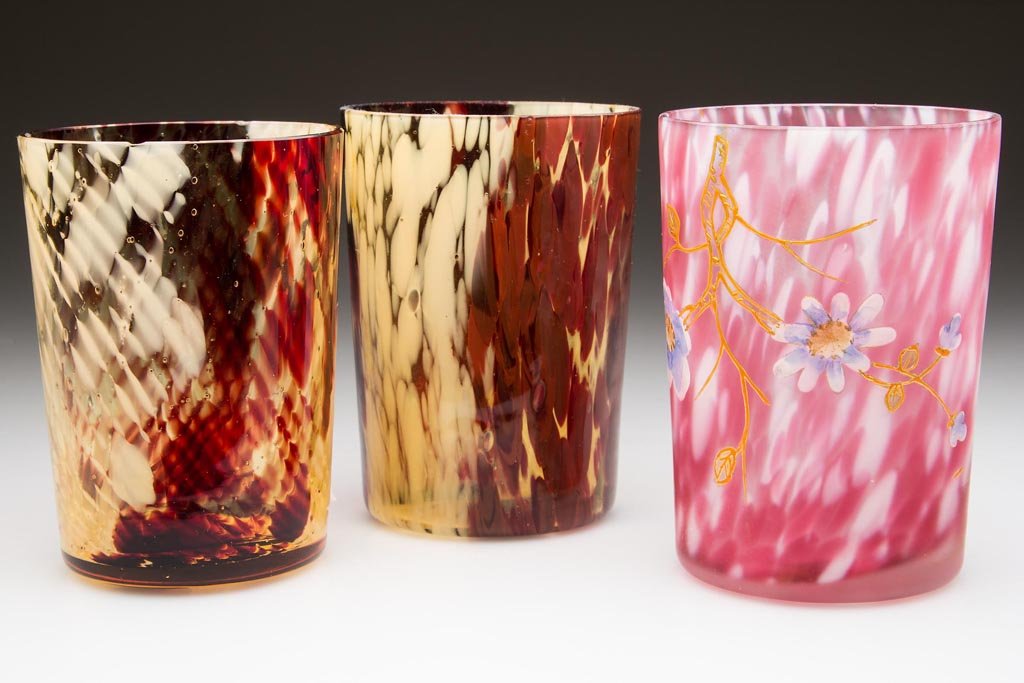ASSORTED SPATTER TUMBLERS, LOT OF THREE: ASSORTED SPATTER TUMBLERS, LOT OF THREE, comprising a ruby and opal example with well-done polychrome enamel and gilt floral decoration, a dark ruby and ivory Fine Swirl, and a dark ruby and ivory unp