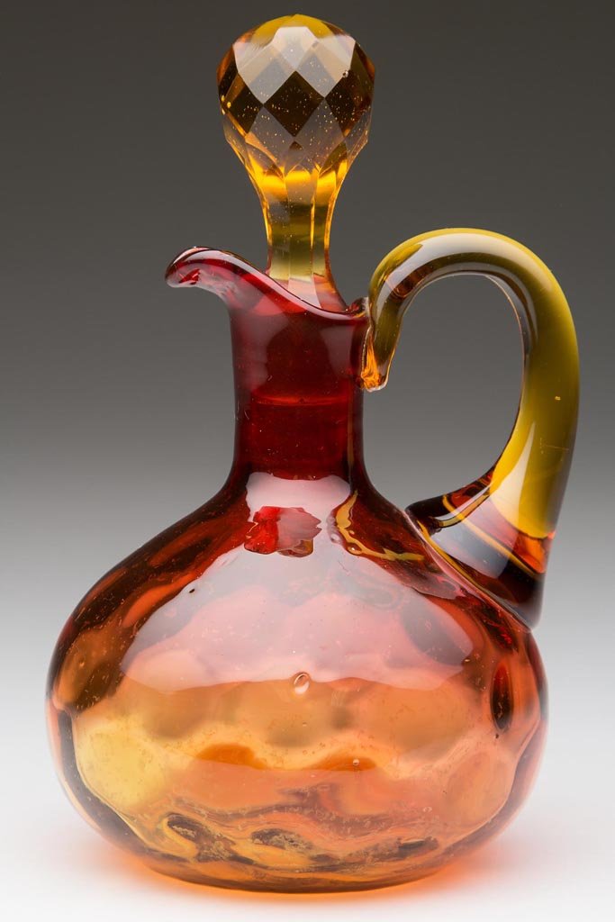 POLKA DOT / SPOT-OPTIC CRUET: POLKA DOT / SPOT-OPTIC CRUET, amberina, applied amber handle, original amber facet-cut stopper, polished pontil mark. Phoenix Glass Co. and others. Fourth quarter 19th century. 5 1/2" HOA. Provenance: