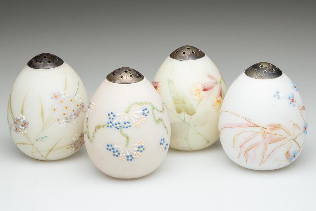 ASSORTED MT. WASHINGTON OSTRICH EGG SALT SHAKERS, LOT: ASSORTED MT. WASHINGTON OSTRICH EGG SALT SHAKERS, LOT OF FOUR, opal with various grounds, plush/satin finish, each with polychrome floral decoration and period lids, one with original paper labels. Mt