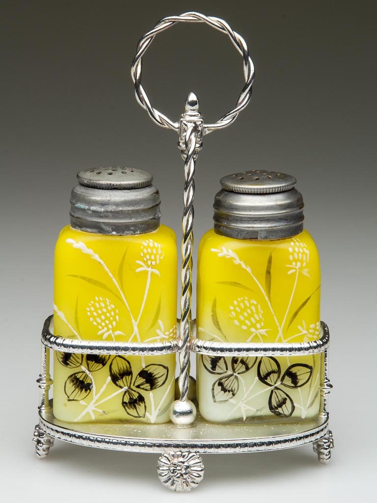 CLOVER AND TIMOTHY PAIR OF SALT AND PEPPER SHAKERS: CLOVER AND TIMOTHY PAIR OF SALT AND PEPPER SHAKERS, cased opaque yellow to white, with polychrome enamel decoration, gilt highlights, a fire polished base and matching, period two-part lids. Fitted in