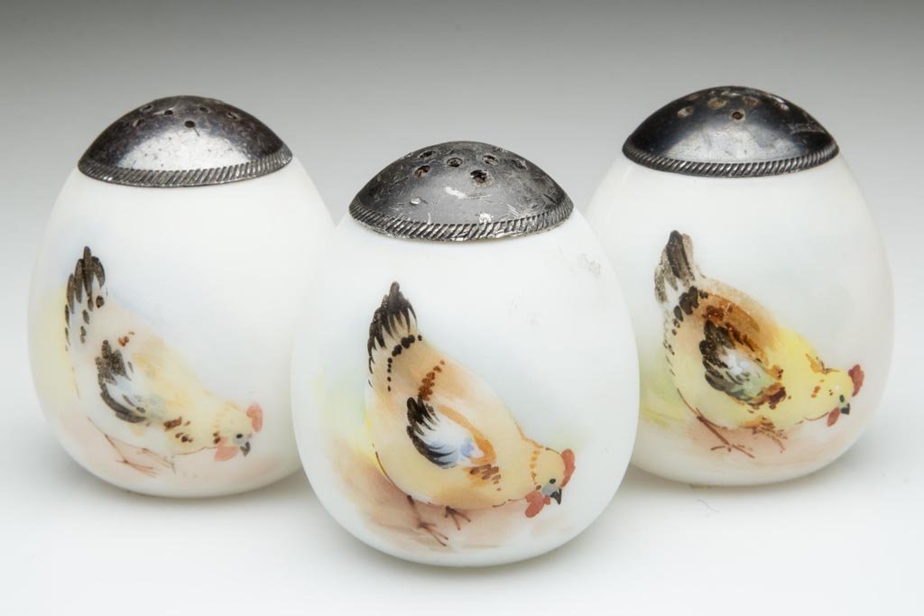 PAIRPOINT EGG - FLAT-END SALT SHAKERS, LOT OF THREE: PAIRPOINT EGG - FLAT-END SALT SHAKERS, LOT OF THREE, opaque white, plush/satin finish, with polychrome hen decorations and matching period lids. Attributed to Pairpoint Glass Co. Fourth quarter 19th c