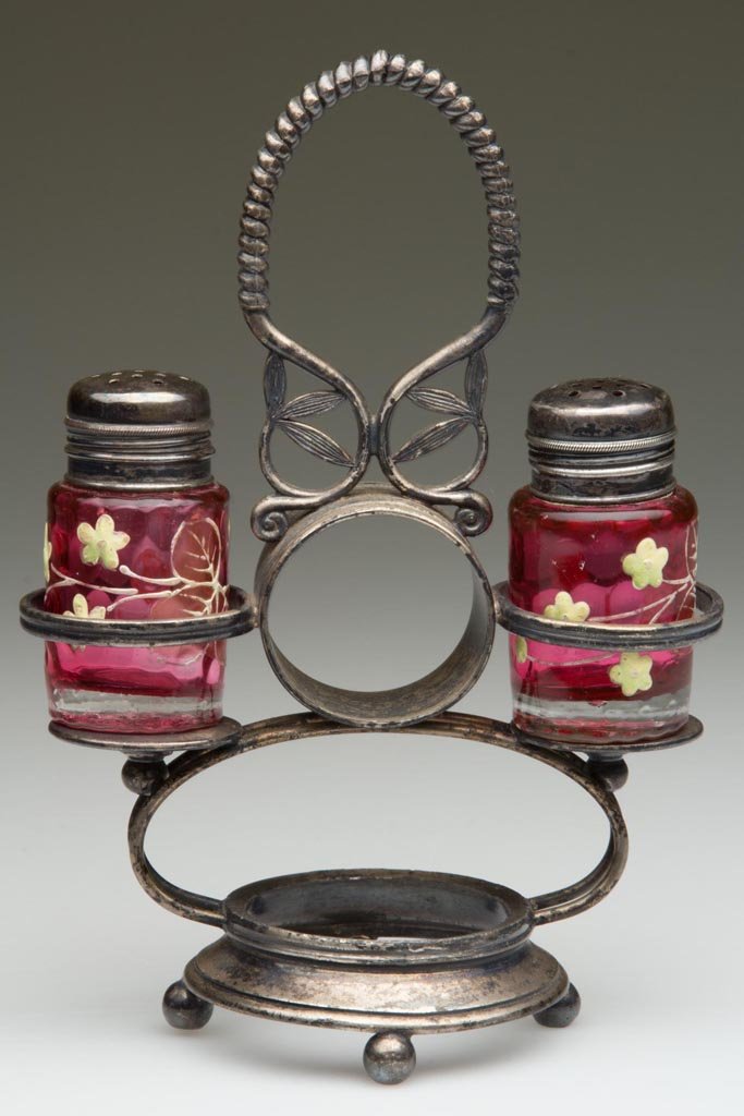 INVERTED THUMBPRINT SHORT PILLAR PAIR OF SALT AND: INVERTED THUMBPRINT SHORT PILLAR PAIR OF SALT AND PEPPER SHAKERS, cased cranberry, with polychrome floral decoration and matching, period two-part lids. Fitted in a quadruple-plate stand with a center