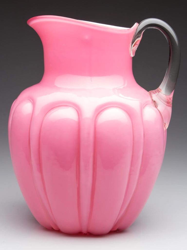 BULGING LOOPS WATER PITCHER: BULGING LOOPS WATER PITCHER, opal cased pink, with colorless applied handle and polished pontil mark. Consolidated Glass Co. Fourth quarter 19th century. 8 7/8" HOA. Provenance: Collection of Jessie a