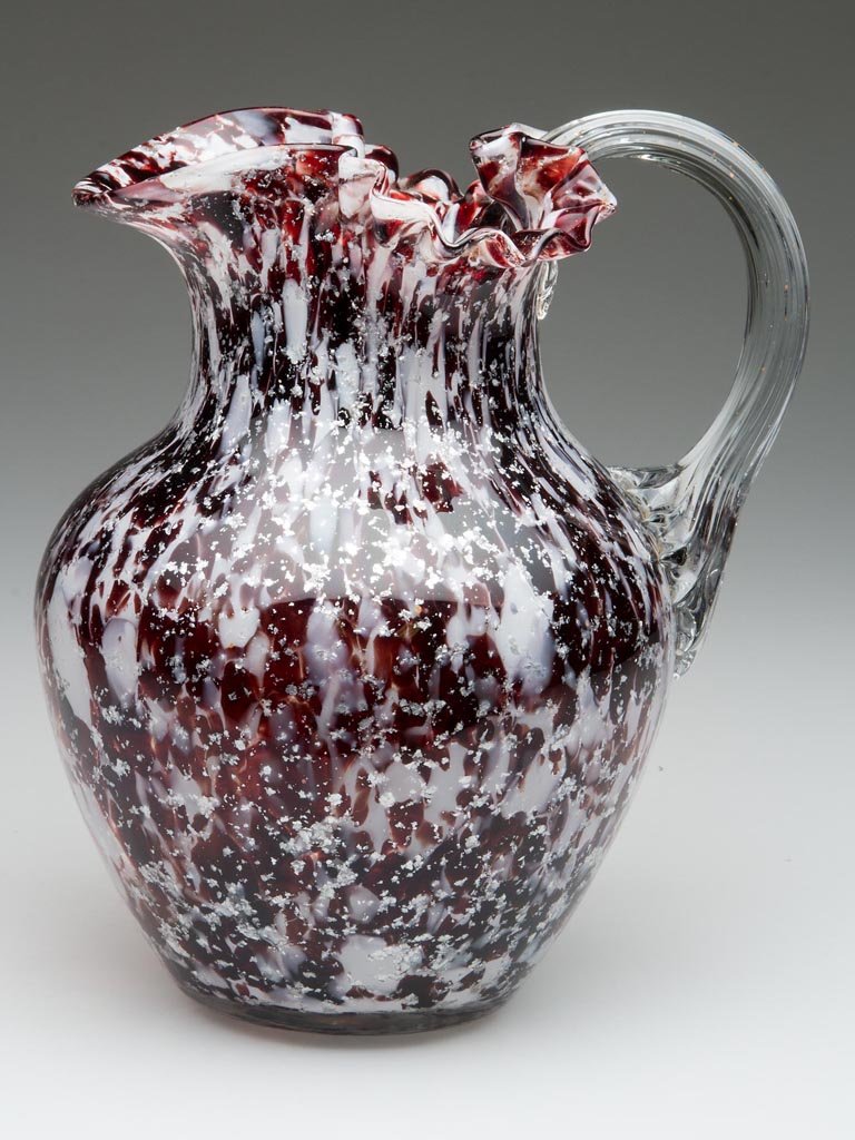 PHOENIX SPOT-OPTIC WATER PITCHER: PHOENIX SPOT-OPTIC WATER PITCHER, colorless with mica, opal, and blood red flakes, shouldered form with crimped top, U-shape spout, applied colorless reeded handle, and polished pontil mark. Phoenix G