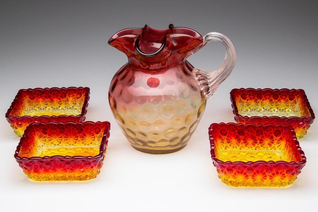 ASSORTED AMBERINA ARTICLES, LOT OF FIVE: ASSORTED AMBERINA ARTICLES, LOT OF FIVE, comprising a Spot Optic pitcher with reeded handle and polished pontil mark, and four L. G. Wright Daisy and Button square sauce dishes. Late 19th and mid 20th