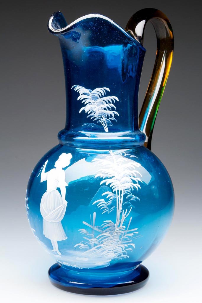 MARY GREGORY (SO CALLED) PANEL-OPTIC WATER PITCHER: MARY GREGORY (SO CALLED) PANEL-OPTIC WATER PITCHER, blue, with white enamel decoration depicting a young lady, bulbous base and cylindrical neck, amber applied handle, ground pontil mark. Late 19th/ea