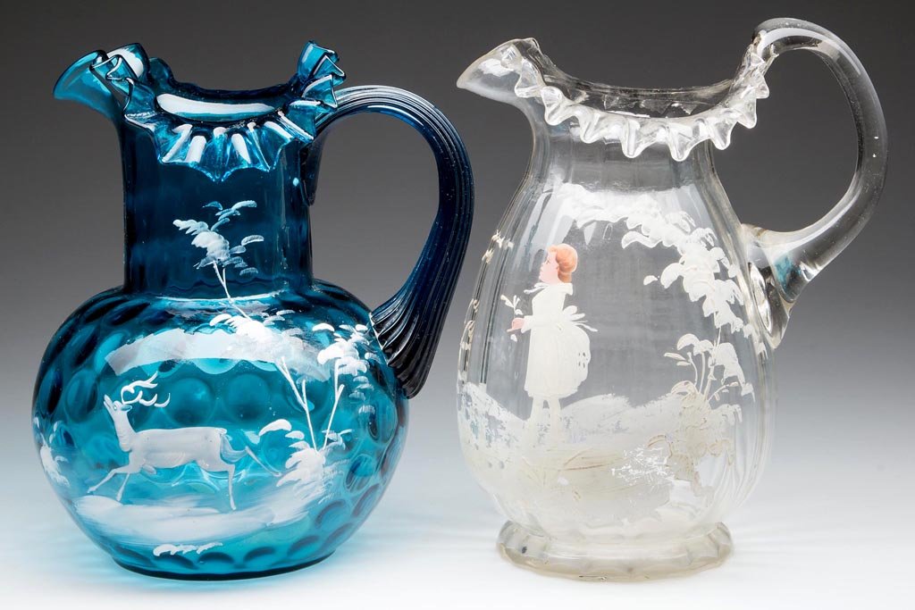MARY GREGORY (SO CALLED) WATER PITCHERS, LOT OF TWO: MARY GREGORY (SO CALLED) WATER PITCHERS, LOT OF TWO, comprising a blue Inverted Thumbprint example depicting a deer and a colorless Panel-Optic example depicting a young lady, each with crimped rims, 