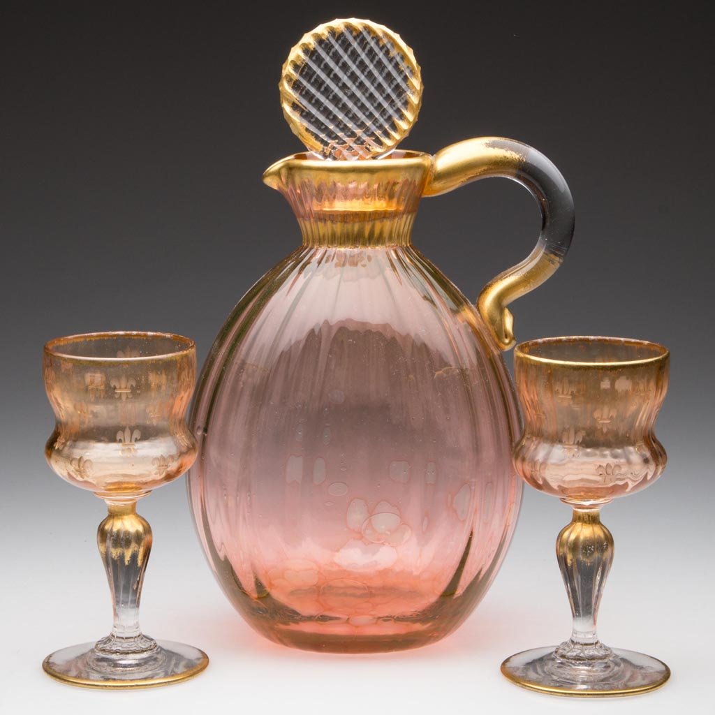 FRENCH DAUM RIB-OPTIC DECANTER AND TWO WINE GLASSES: FRENCH DAUM RIB-OPTIC DECANTER AND TWO WINE GLASSES, pink and colorless with gilt decorations, decanter with applied handle and original cut stopper, each wine with a thistle-shape bowl engraved with 