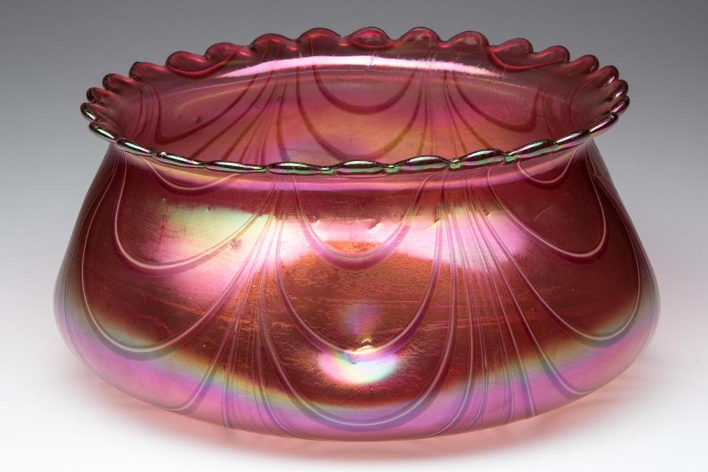 LOETZ-TYPE BOHEMIAN PINCHED BOWL: LOETZ-TYPE BOHEMIAN PINCHED BOWL, ruby iridescent ground, ruby and opal marbrie loop/drape decoration off the scalloped rim, polished pontil mark. Bohemia. Circa 1900. 4" H, 8" D rim. Provenance: Prop