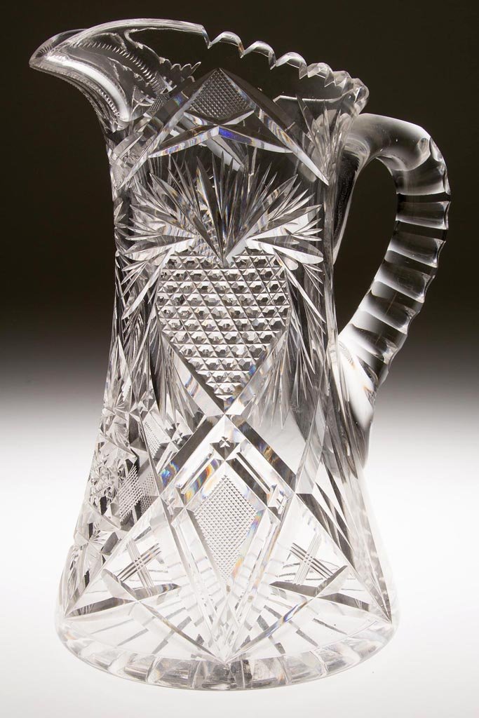 "HEART" AMERICAN BRILLIANT CUT GLASS PITCHER: "HEART" AMERICAN BRILLIANT CUT GLASS PITCHER, colorless, heart over miters and fine-point pattern, handle with cut punties. Possibly H. C. Fry Glass Co. Early 20th century. 10 1/2" HOA. Literature: H.