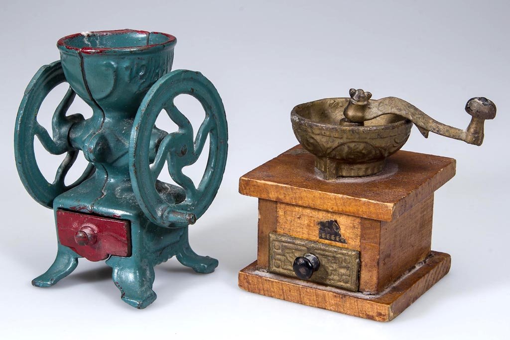 CAST-IRON AND WOOD TOY COFFEE GRINDERS, LOT OF TWO: CAST-IRON AND WOOD TOY COFFEE GRINDERS, LOT OF TWO, comprising a two-wheel mill and a crank grinder, each with lower drawer and original surfaces. Late 19th/early 20th century. 4" and 3 1/2" H. Proven