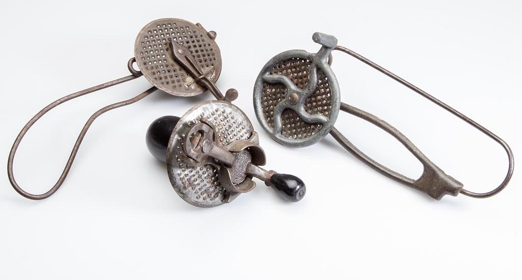 VINTAGE IRON AND TIN MECHANICAL NUTMEG GRATERS, LOT OF: VINTAGE IRON AND TIN MECHANICAL NUTMEG GRATERS, LOT OF THREE, two with rotating wheel and one with rotating press. Late 19th/first quarter 20th century. 3 1/2" to 7" L. Provenance: Property of a Maryl