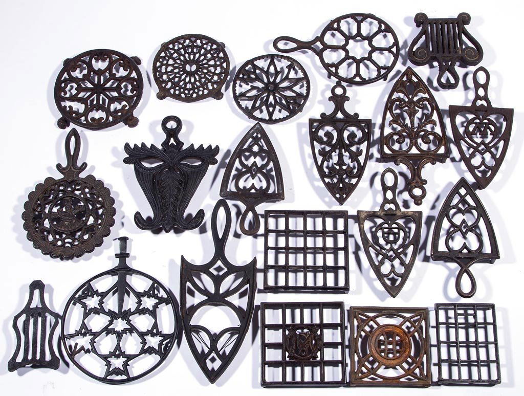 ASSORTED CAST-IRON FLATIRON TRIVETS, LOT OF 20: ASSORTED CAST-IRON FLATIRON TRIVETS, LOT OF 20, including various decorative motifs. Most with original surface. Mostly second half 19th/early 20th century. Various sizes.