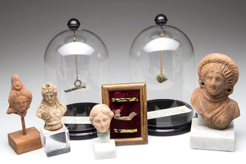 ASSORTED TERRACOTTA AND METAL ANTIQUITIES, LOT OF SEVEN: ASSORTED TERRACOTTA AND METAL ANTIQUITIES, LOT OF SEVEN, including four bust fragments, a labeled Roman phallic amulet, and a labeled Egyptian ring fragment, each mounted. 2 1/2" to 6 1/2" HOA. Proven
