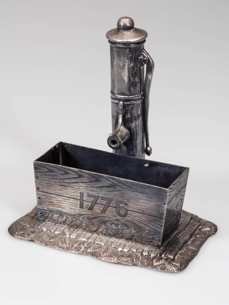 AMERICAN VICTORIAN QUADRUPLE-PLATE FIGURAL CARD: AMERICAN VICTORIAN QUADRUPLE-PLATE FIGURAL CARD RECEIVER, depicting a town water pump and tough engraved "1776", marked for James W. Tufts, #2614, and design patented Jan. 13, 1880. Fourth quarter 19t