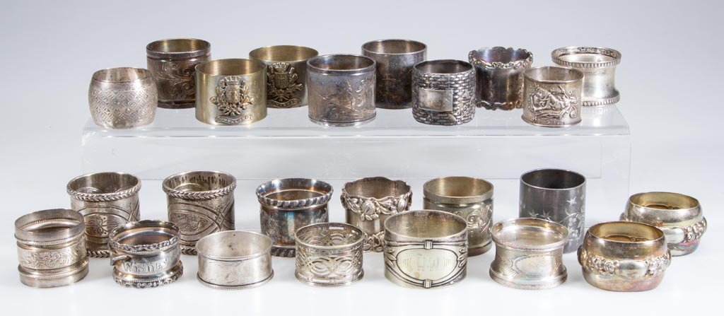 VICTORIAN SILVER-PLATE NAPKIN RINGS, LOT OF 24: VICTORIAN SILVER-PLATE NAPKIN RINGS, LOT OF 24, ornamentations include basketweave and dragonfly, wishbone, and a fisherman. Some possibly sterling silver. Late 19th/first quarter 20th century. Variou
