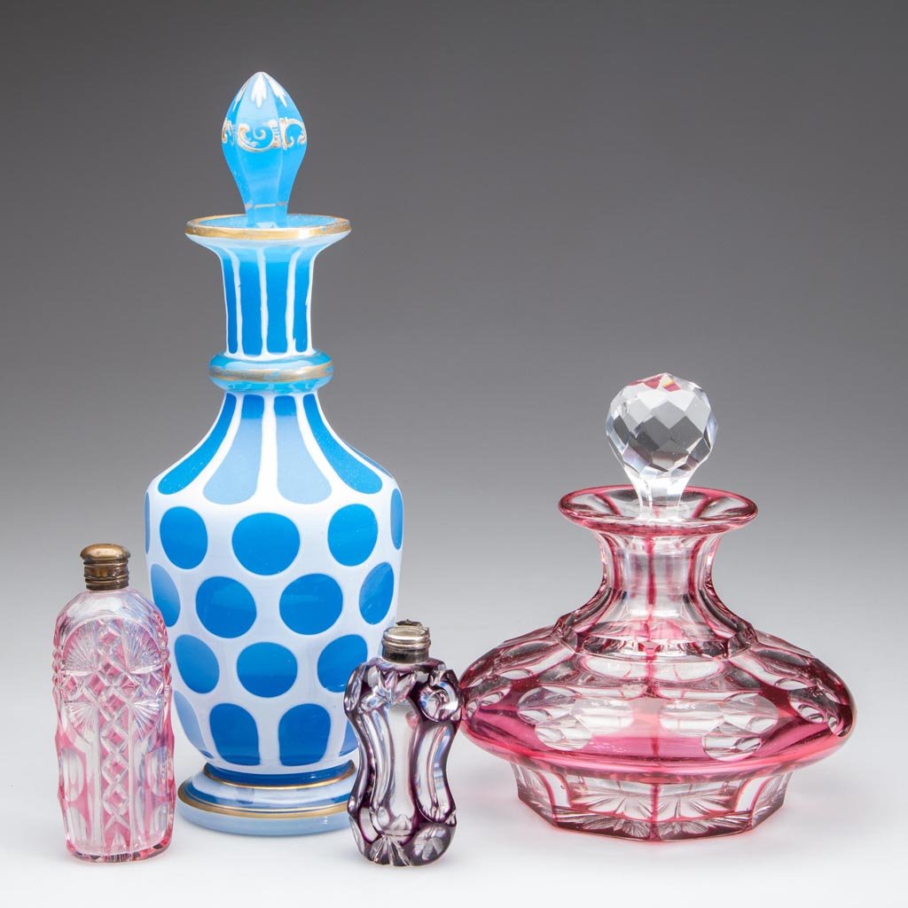 ASSORTED CUT OVERLAY GLASS COLOGNE / SCENT BOTTLES, LOT: ASSORTED CUT OVERLAY GLASS COLOGNE / SCENT BOTTLES, LOT OF FOUR, including white cut to starch blue and ruby cut to colorless, inappropriate stoppers, one scent lacking cap. Second half 19th century. 