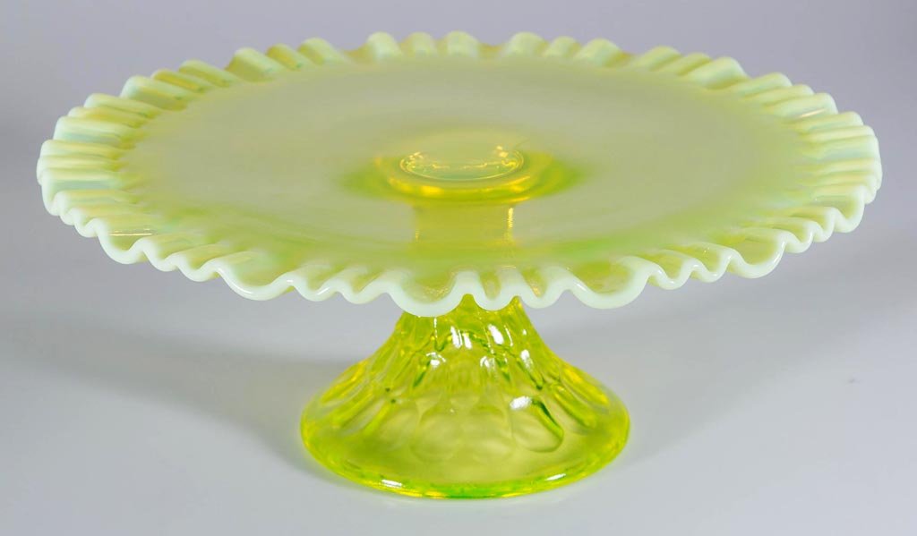 UNIDENTIFIED THUMBPRINT CAKE STAND: UNIDENTIFIED THUMBPRINT CAKE STAND, vaseline (uranium) opalescent, base with thumbprint and twist design. 20th century. 4 3/4" H, 12 1/4" D plate. Provenance: Property of the Estate of Cheryl M. Kelle