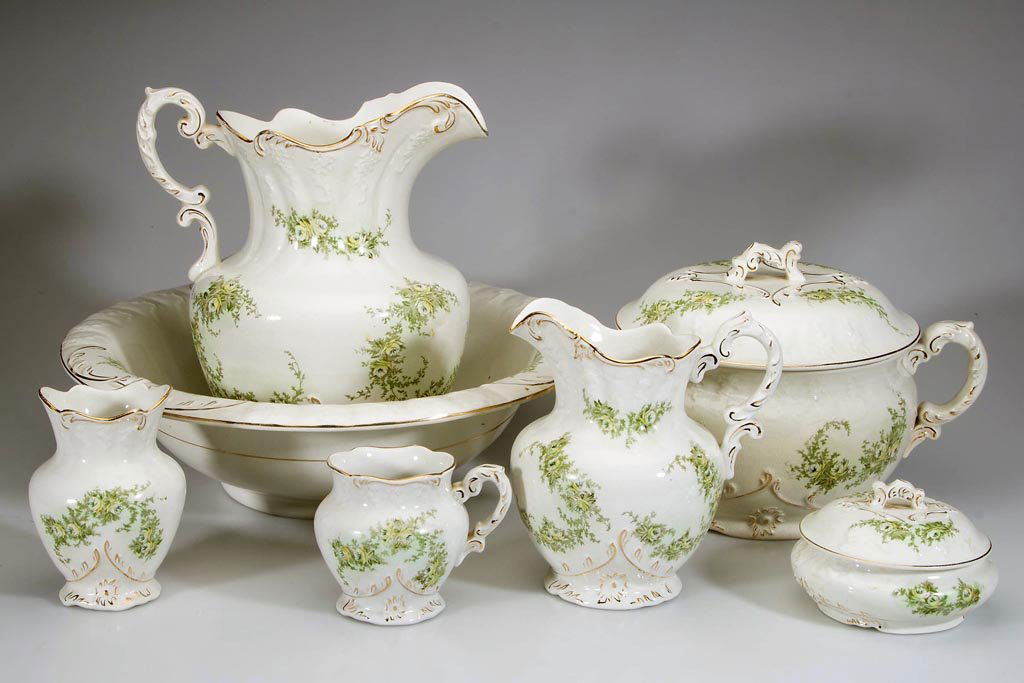 LATE VICTORIAN AMERICAN CERAMIC SEVEN-PIECE WASH BOWL: LATE VICTORIAN AMERICAN CERAMIC SEVEN-PIECE WASH BOWL AND PITCHER SET, green and yellow floral transfer decoration with gilding, comprising a wash bowl and pitcher, hot water pitcher, covered potty, t