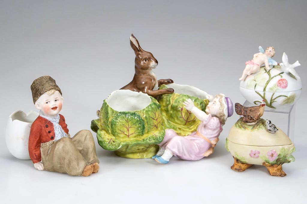 CONTINENTAL CERAMIC FIGURES, LOT OF FOUR: CONTINENTAL CERAMIC FIGURES, LOT OF FOUR, comprising two egg-form covered boxes including one with a hen and chick and other with a cherub and dove; a Heubach toothpick holder with young boy and broke