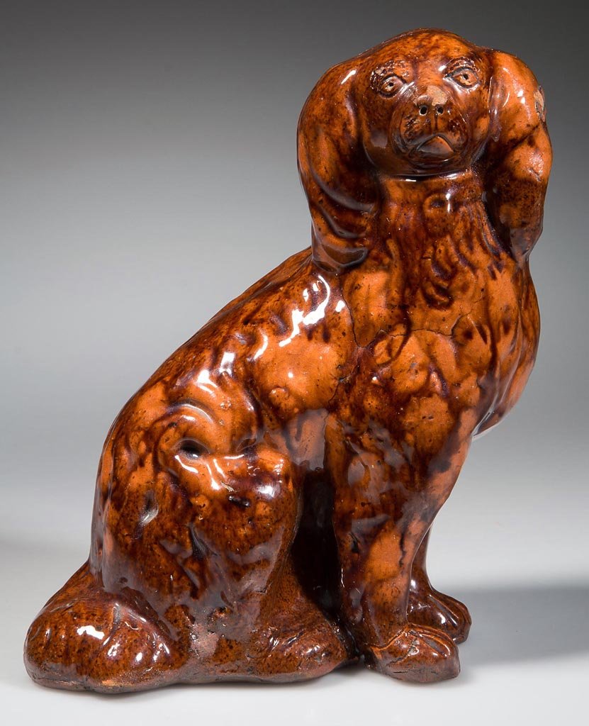 BELL FAMILY (ATTRIBUTED) DECORATED EARTHENWARE /: BELL FAMILY (ATTRIBUTED) DECORATED EARTHENWARE / REDWARE SPANIEL FIGURE, facing right, lead-glazed with manganese mottling, small hollow seated figure molded after a corresponding English Staffordshir