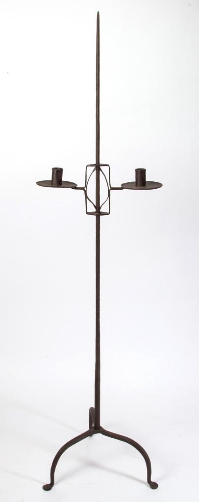 AMERICAN WROUGHT-IRON FLOOR CANDLE STAND: AMERICAN WROUGHT-IRON FLOOR CANDLE STAND, tapered shaft supporting an adjustable two-arm candleholder with circular pans, raised on a tripod base terminating in penny feet. 19th or 20th century. 56 1/