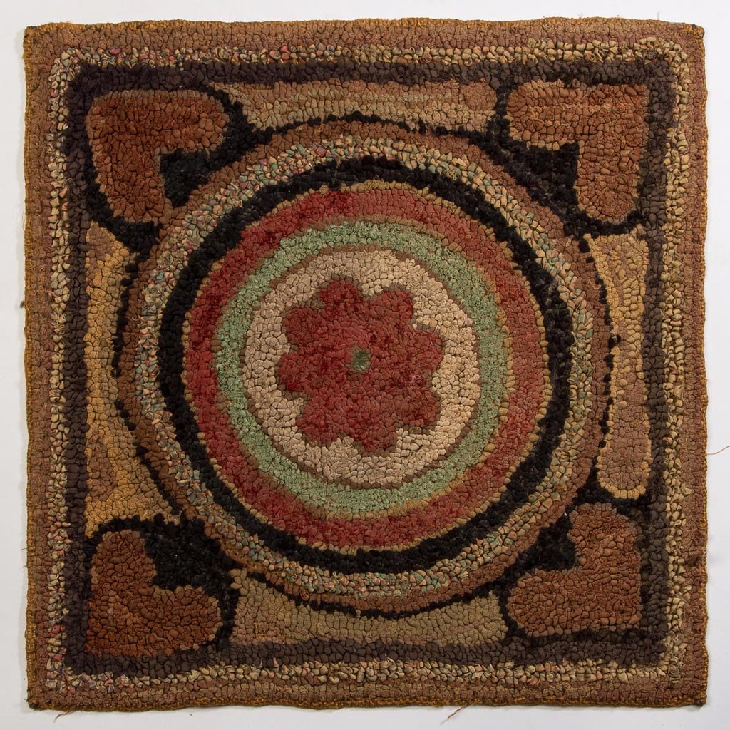 AMERICAN FOLK ART HOOKED MAT: AMERICAN FOLK ART HOOKED MAT, wool and cotton on burlap, a charming example, featuring a floral device centered by concentric circles and framed by four hearts in the corners. Circa 1880-1900. 15" x 1