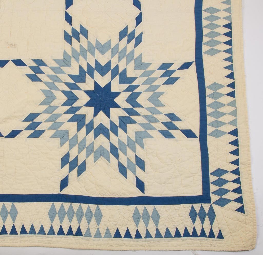 AMERICAN STAR PATTERN PIECED QUILT: AMERICAN STAR PATTERN PIECED QUILT, blue and white, sawtooth border, plume, wreath, and pinwheel quilting, white backing. First half 20th century. 104" x 81. Provenance: Collection of the late John an