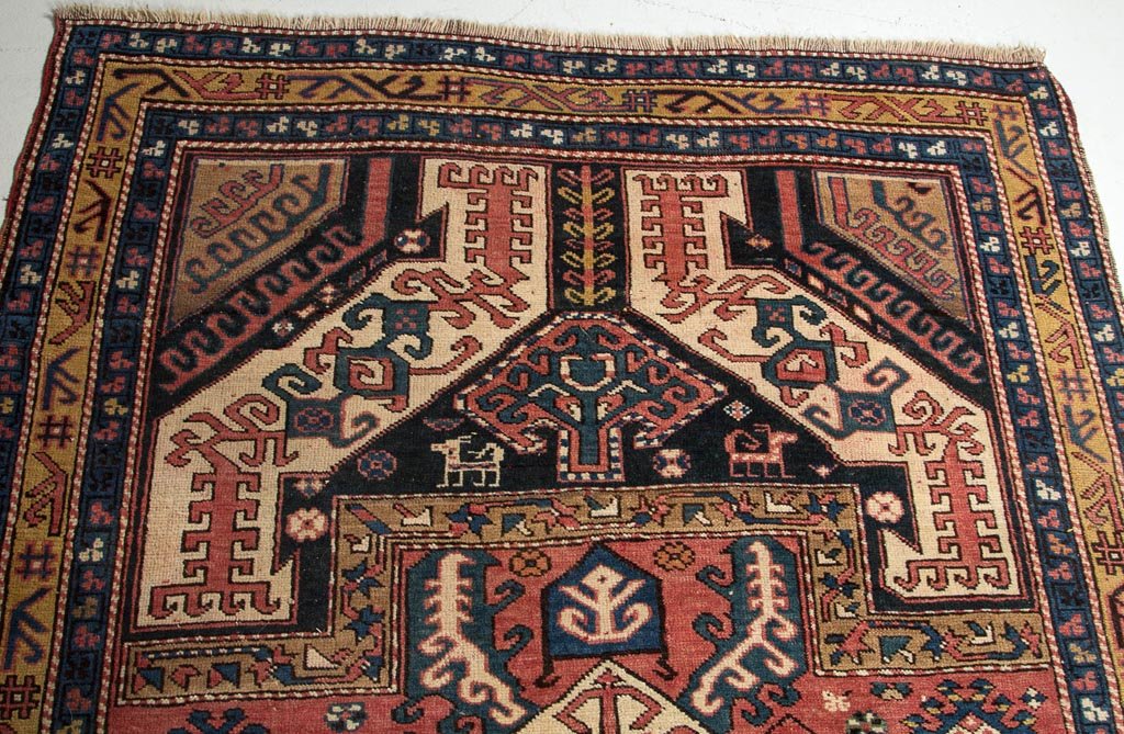 ANTIQUE TRIBAL ORIENTAL SCATTER RUG: ANTIQUE TRIBAL ORIENTAL SCATTER RUG, stylized-geometric design with central medallion and several scattered small animals. First half 20th century. 7' 10" x 4' 5". Provenance: Collection of the late J