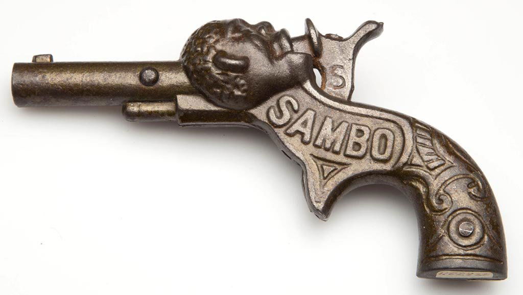 CAST-IRON "SAMBO" FIGURAL CAP PISTOL: CAST-IRON "SAMBO" FIGURAL CAP PISTOL, name on one side and 1887 and 1890 patent dates on other side. Circa 1890-1900. 4 3/4" L. Provenance: Collection of the late John and Lil Palmer, Purcellville, VA