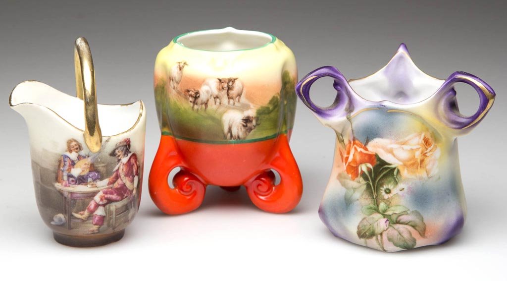 ROYAL BAYREUTH PORCELAIN TOOTHPICK HOLDERS, LOT OF: ROYAL BAYREUTH PORCELAIN TOOTHPICK HOLDERS, LOT OF THREE, comprising a Cavalier Musicians bucket with handle, a Highland Sheep on three feet, and a floral with three handles. One with printed blue mar