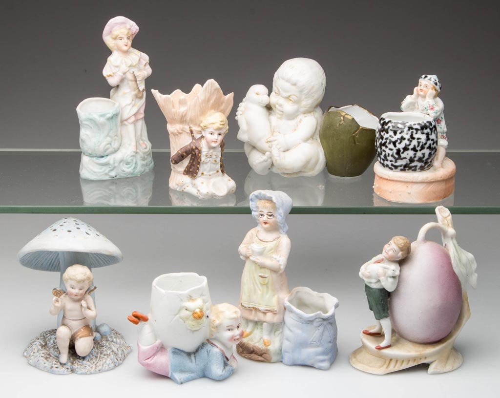 ASSORTED BISQUE FIGURAL TOOTHPICK HOLDERS, LOT OF EIGHT: ASSORTED BISQUE FIGURAL TOOTHPICK HOLDERS, LOT OF EIGHT, depicting children, four posed with an animal. Germany. Late 19th/early 20th century. 2 3/8" to 4" H. Provenance: From the collection of Betty