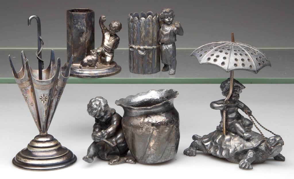 VICTORIAN SILVER-PLATE FIGURAL TOOTHPICK HOLDERS, LOT: VICTORIAN SILVER-PLATE FIGURAL TOOTHPICK HOLDERS, LOT OF FIVE, including a Pairpoint child on turtle with parasol and a German kneeling child playing with cat. Fourth quarter 19th/early 20th century.