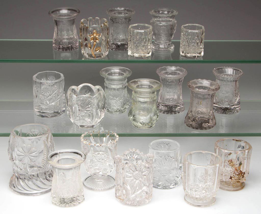 ASSORTED EAPG TOOTHPICK HOLDERS, LOT OF 20: ASSORTED EAPG TOOTHPICK HOLDERS, LOT OF 20, colorless, each with floral or fruit pattern. Late 19th/first quarter 20th century. 1 3/4" to 3 1/4" H. Provenance: From the collection of Betty and Jim MaG