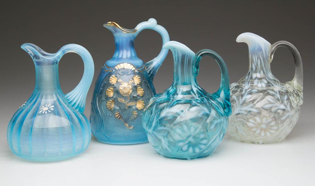 ASSORTED OPALESCENT GLASS CRUETS, LOT OF FOUR: ASSORTED OPALESCENT GLASS CRUETS, LOT OF FOUR, blue and colorless opalescent, comprising two Daisy and Fern in Parian Swirl mold and with applied handles, an Everglades, and a Jackson, each lacking st