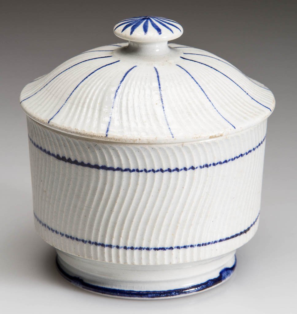 ENGLISH STAFFORDSHIRE POTTERY PEARLWARE DIMINUTIVE: ENGLISH STAFFORDSHIRE POTTERY PEARLWARE DIMINUTIVE SUGAR BOWL AND COVER, the cylindrical, swirl-molded body on foot, with conforming cover and button knop, painted with sparse blue lines to the edges.