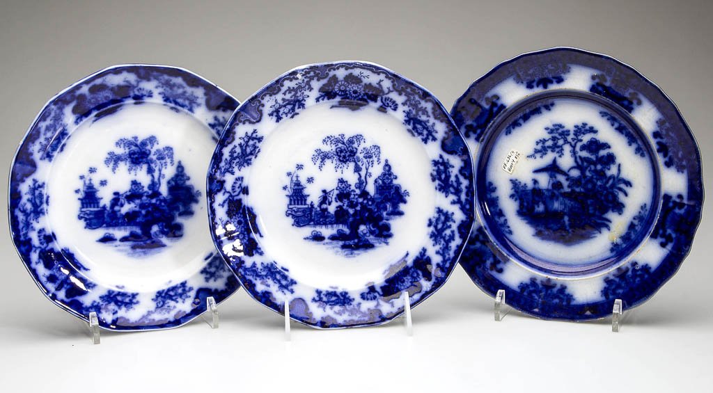 ENGLISH IRONSTONE POTTERY FLOW BLUE PLATES, LOT OF: ENGLISH IRONSTONE POTTERY FLOW BLUE PLATES, LOT OF THREE, comprising one Davenport "Amoy" pattern and two Alcock "Scinde" pattern, with lightly-molded rims, printed in dark, flowing blue with the patt
