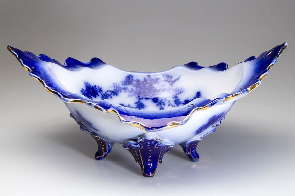 WHEELING POTTERY, WHEELING, WEST VIRGINIA FLOW BLUE "LA: WHEELING POTTERY, WHEELING, WEST VIRGINIA FLOW BLUE "LA BELLE CHINA" PATTERN CENTERPIECE, the tripodal ovate centerpiece with irregularly scalloped and lightly-molded border, printed with blue floral