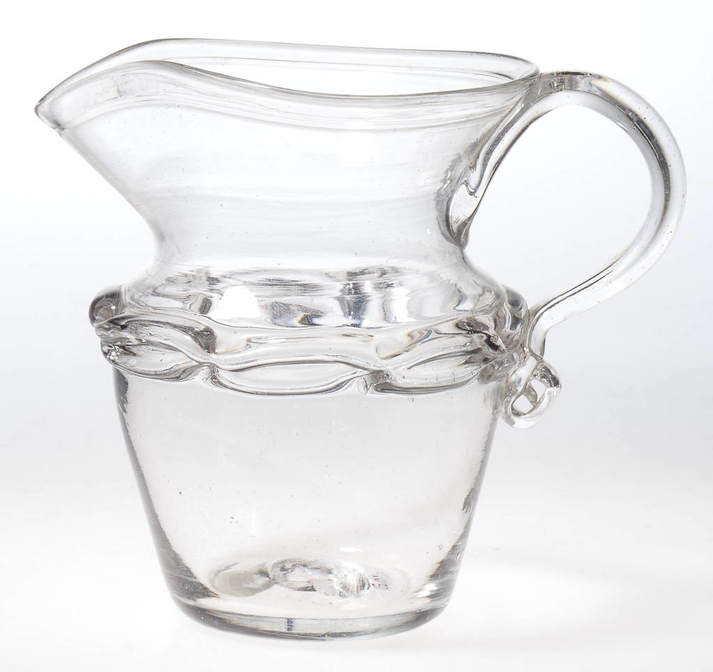 FREE-BLOWN THOMAS CAINS CHAIN-DECORATED CREAM JUG: FREE-BLOWN THOMAS CAINS CHAIN-DECORATED CREAM JUG, colorless, truncated conical body with medial shoulder featuring a pinched-chain band, boldly flared and tooled rim, applied solid handle, and rough 