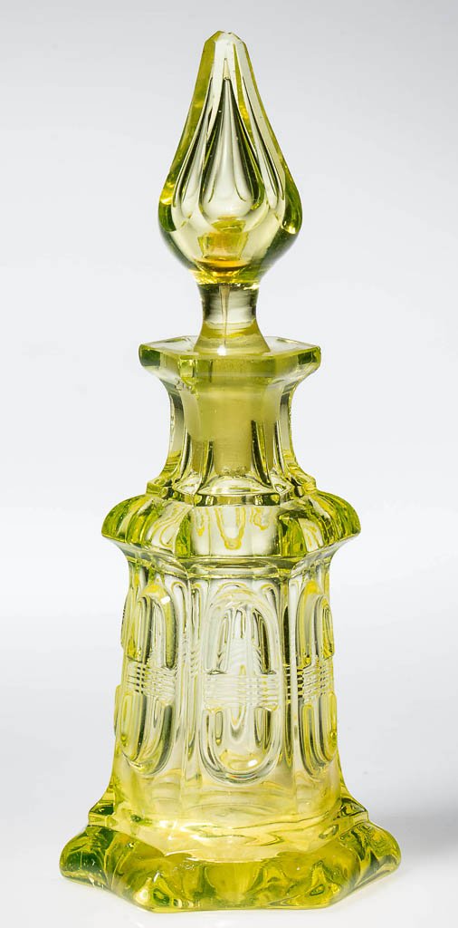 ELONGATED LOOP WITH BISECTING LINES COLOGNE BOTTLE: ELONGATED LOOP WITH BISECTING LINES COLOGNE BOTTLE, canary yellow (uranium), hexagonal bottle with factory polished mouth, flanged foot, and cut-and-shut scar under base, appropriate panel-cut air-tra