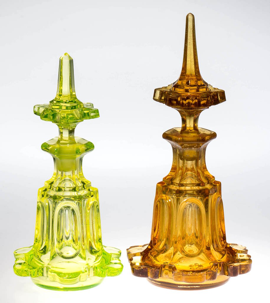 PRESSED ELONGATED LOOP COLOGNE BOTTLES, LOT OF TWO: PRESSED ELONGATED LOOP COLOGNE BOTTLES, LOT OF TWO, bright canary/vaseline (uranium) and medium amber with worn gilt decorations, comprising a small- and a medium-size hexagonal bottle, each with flan