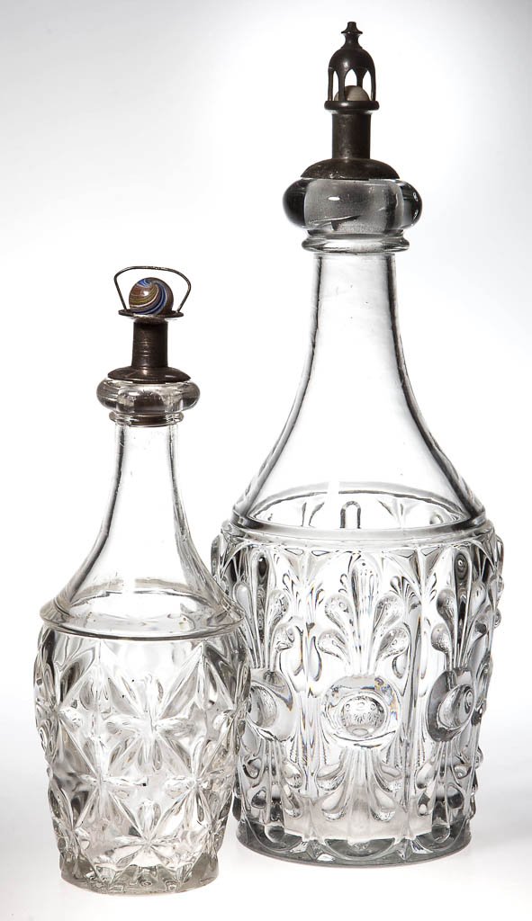 ASSORTED PATTERN BAR DECANTERS, LOT OF TWO: ASSORTED PATTERN BAR DECANTERS, LOT OF TWO, colorless lead glass, comprising a Bull's Eye with Fleur-de-lys quart and a Sandwich Star half pint, each with applied bar lip and polished pontil mark. Fit