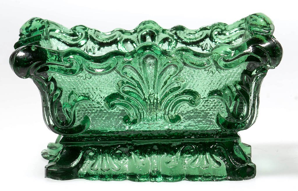 SL-1A SHELL PRESSED OPEN SALT: SL-1A SHELL PRESSED OPEN SALT, medium green, shaped rim. Very rare. Possibly Boston & Sandwich Glass Co. Circa 1835-1850. 1 5/8" H, 2" x 3". Literature: Neal, p. 404. Parallels B & K I, fig. 1457. Pro