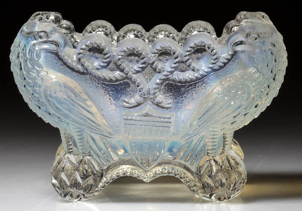EE-3B EAGLE AND SHIELD PRESSED OPEN SALT: EE-3B EAGLE AND SHIELD PRESSED OPEN SALT, light opalescent, on four feet. Rare. Boston & Sandwich Glass Co. Circa 1830-1845. 2 1/8" H, 2" x 3 1/4". Literature: Neal, p. 79. B & K I, fig. 1453. Like El